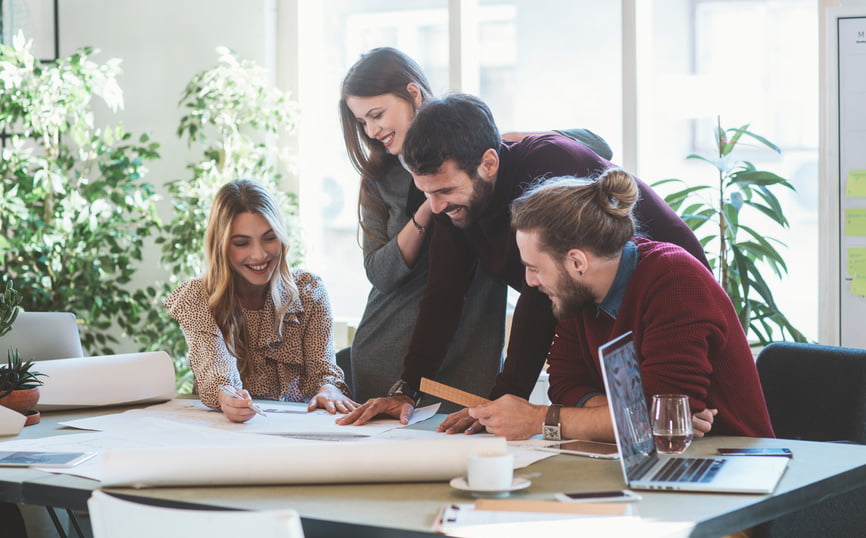 Group of people huddled around a desk
