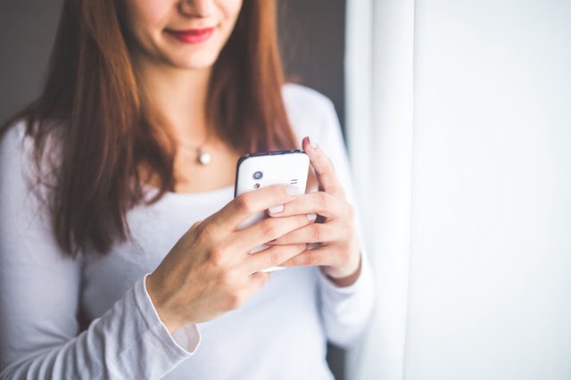 Photo of a woman reading on a phone